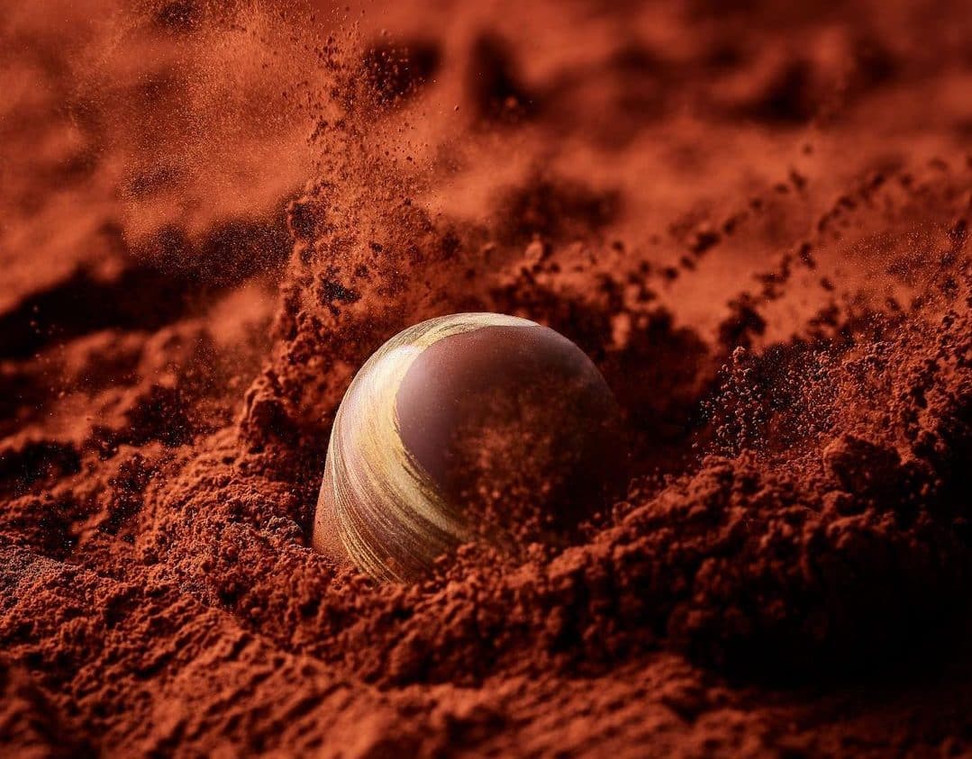A visual of cacao powder and a ball falling into it